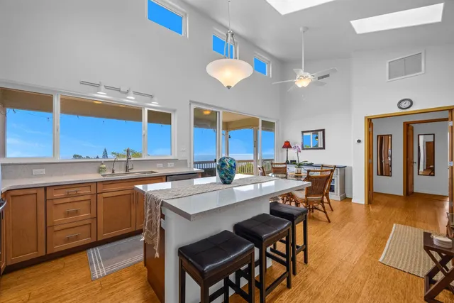 a kitchen with a dining table chairs sink and wooden floor