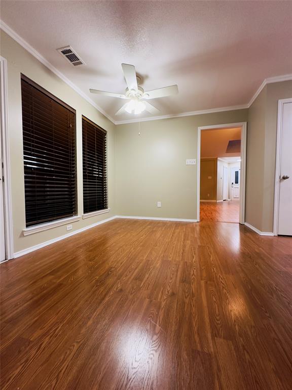 3929 St Christopher Lane Dallas, TX 75287 - Photo 17 of 22 a view of an empty room with wooden floor and a ceiling fan