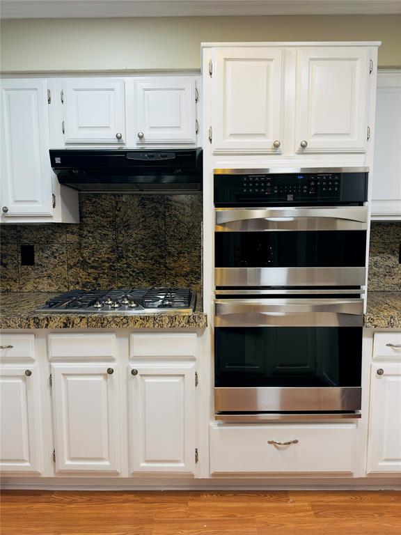 3929 St Christopher Lane Dallas, TX 75287 - Photo 22 of 22 a kitchen with granite countertop white cabinets and stainless steel appliances