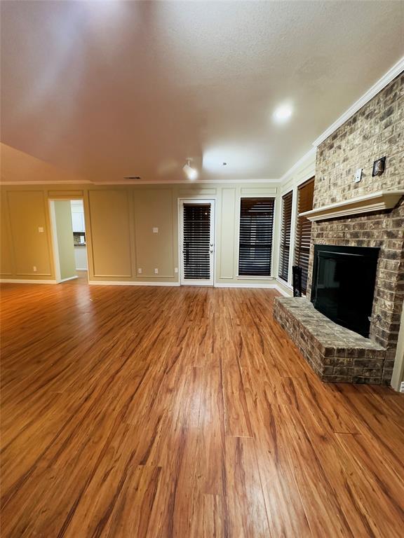 3929 St Christopher Lane Dallas, TX 75287 - Photo 5 of 22 a view of an empty room with wooden floor fireplace and a window