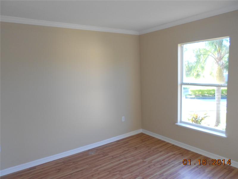 6044 Ridge Lake Circle Vero Beach, FL 32967 - Photo 12 of 14 an empty room with wooden floor and windows