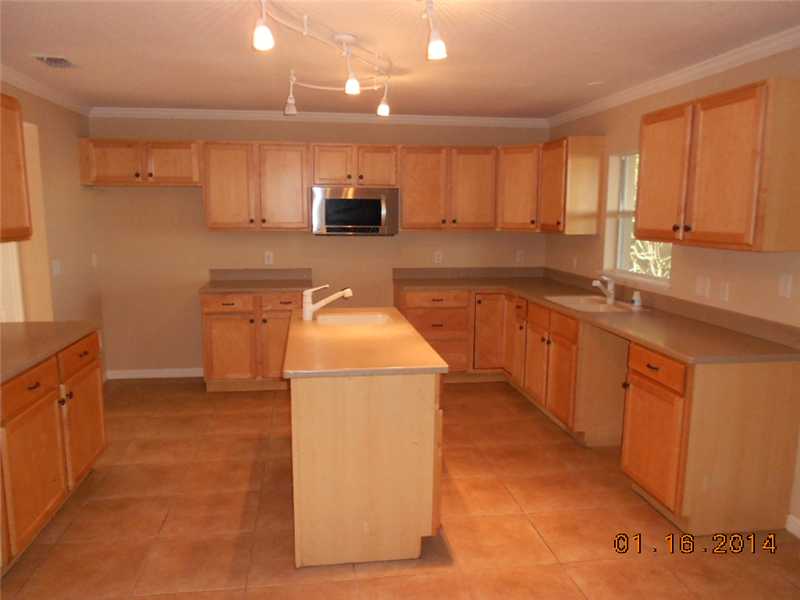 6044 Ridge Lake Circle Vero Beach, FL 32967 - Photo 4 of 14 a kitchen with stainless steel appliances granite countertop a sink stove and refrigerator