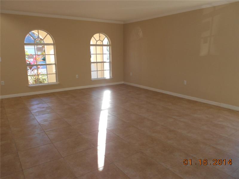 6044 Ridge Lake Circle Vero Beach, FL 32967 - Photo 7 of 14 an empty room with windows and chandelier