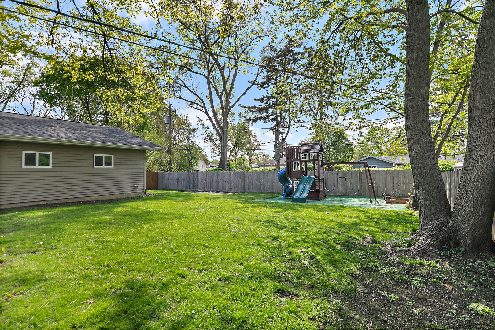 710 Olive Street Hoffman Estates, IL 60169 - Photo 20 of 30 a backyard of a house with plants and large tree