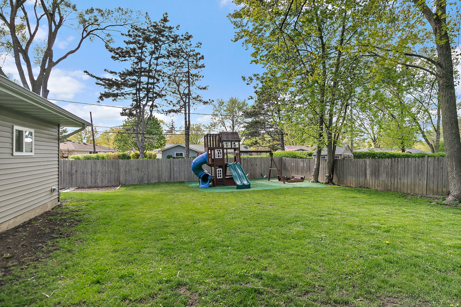 710 Olive Street Hoffman Estates, IL 60169 - Photo 21 of 30 a view of a backyard with a house and large trees with wooden fence