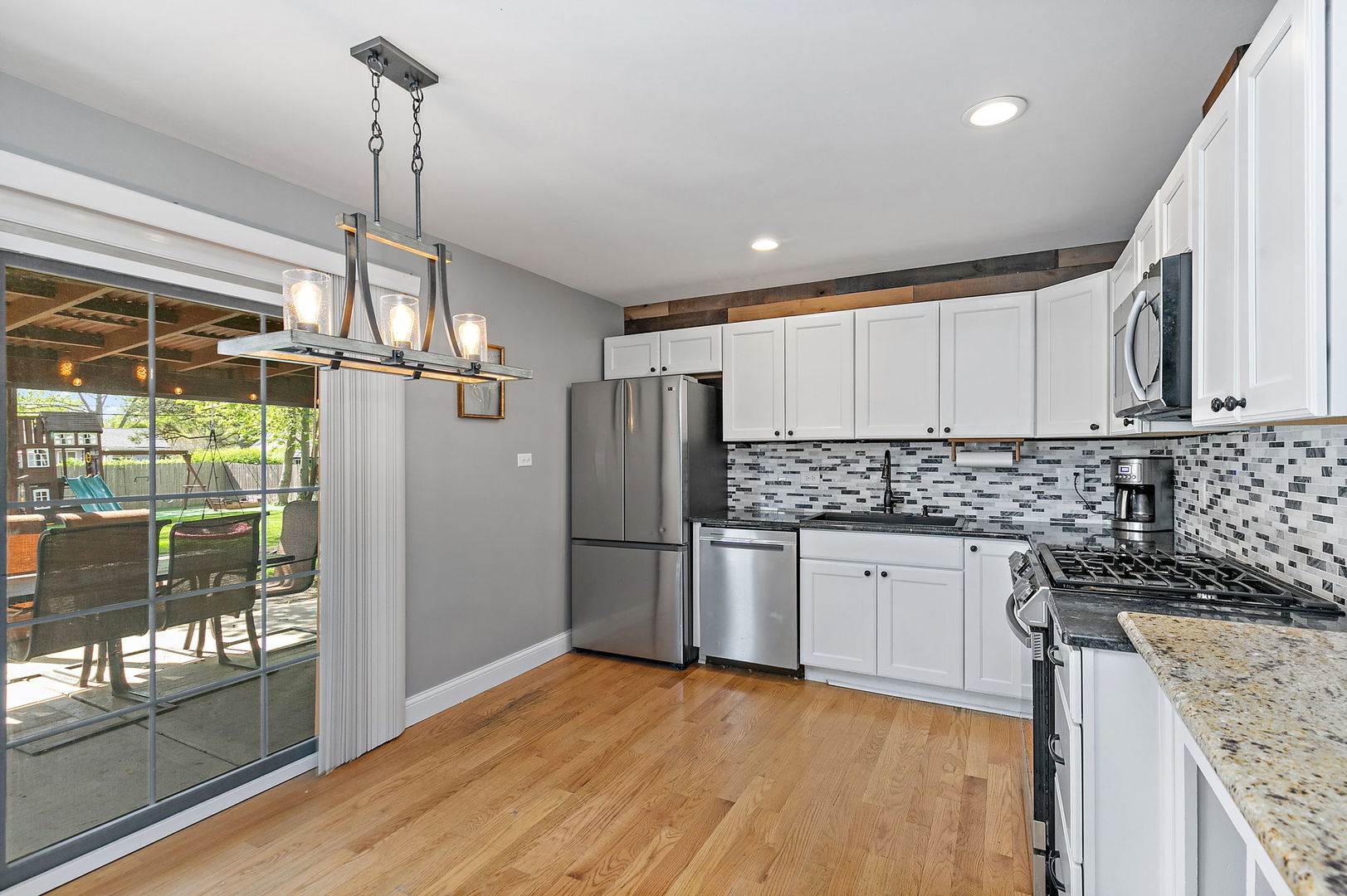 710 Olive Street Hoffman Estates, IL 60169 - Photo 7 of 30 a kitchen with stainless steel appliances granite countertop a refrigerator a sink dishwasher a stove and white cabinets with wooden floor