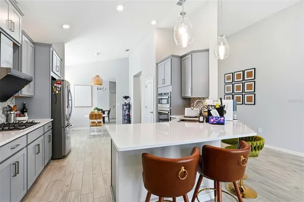 a kitchen with a table chairs stove and wooden floor