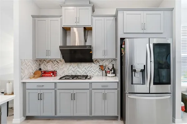 a kitchen with stainless steel appliances white cabinets and a refrigerator