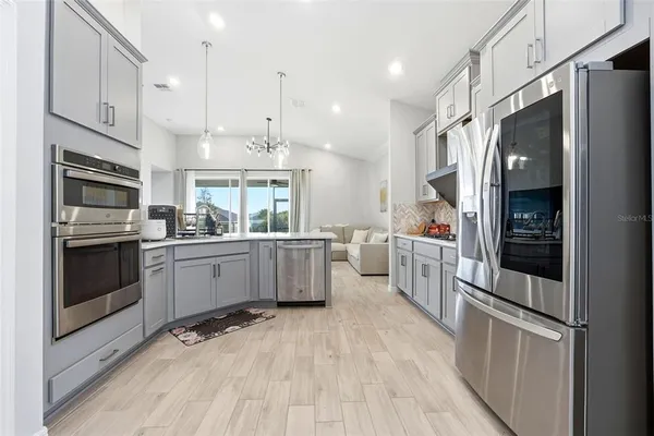 a kitchen with stainless steel appliances a refrigerator sink and microwave