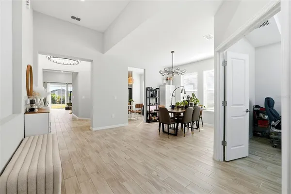 a view of a dining room and livingroom with furniture wooden floor a chandelier