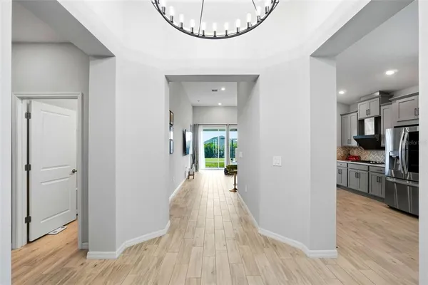 a view of a hallway with wooden floor windows and a living room