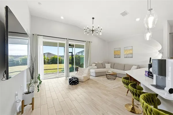 a living room with furniture a flat screen tv and a large window