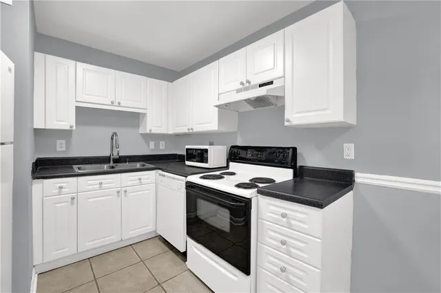 a kitchen with cabinets appliances a sink and a stove
