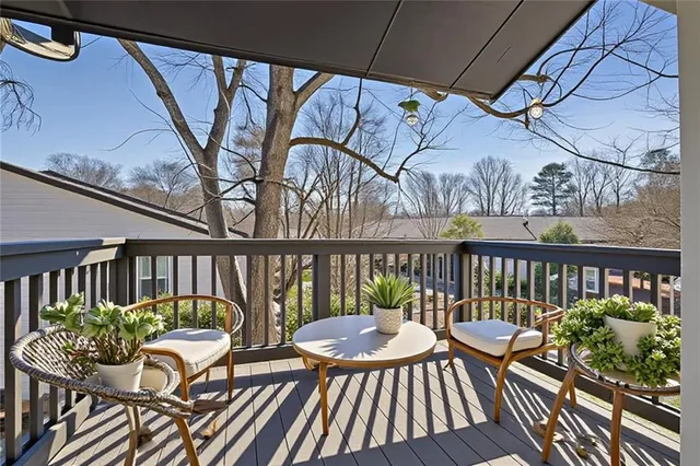 a balcony with wooden floor and outdoor seating