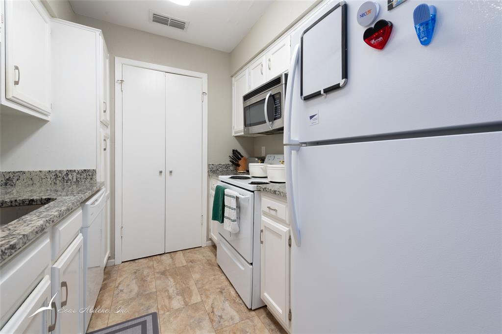 1318 Westheimer Road, Unit 217 Abilene, TX 79601 - Photo 9 of 16 a kitchen with stainless steel appliances granite countertop a refrigerator and a stove
