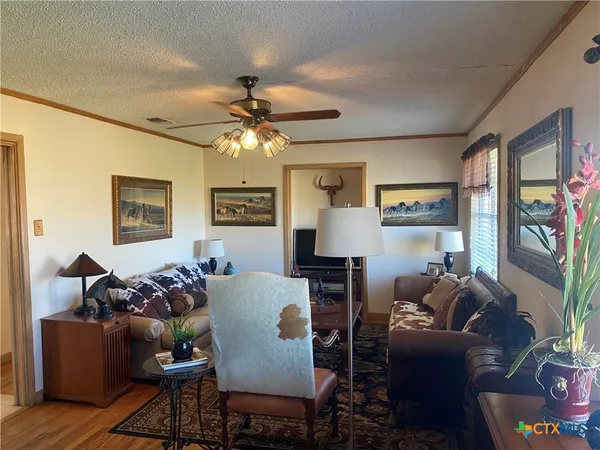 a living room with furniture a chandelier and a window