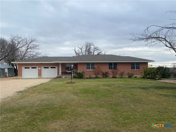 a view of a big house with a big yard and large trees