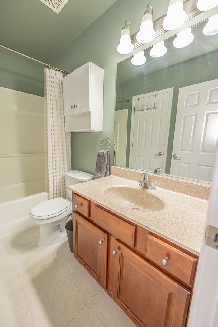 4355 Timber Ridge Court Joliet, IL 60431 - Photo 15 of 24 a bathroom with a granite countertop sink a toilet and a mirror