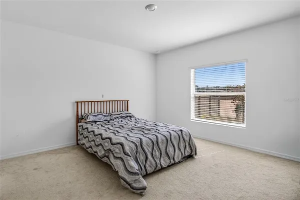 a bed sitting in a bedroom next to a window