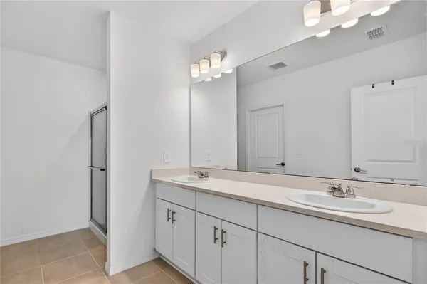 a bathroom with a double vanity sink and a mirror
