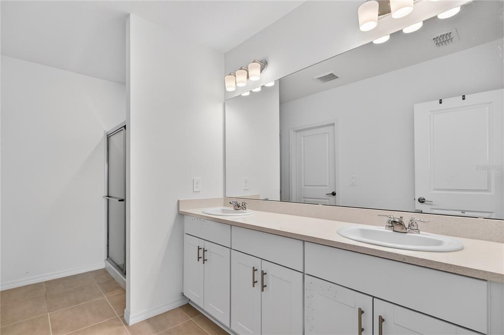 9633 Rampart Road Leesburg, FL 34788 - Photo 15 of 34 a bathroom with a double vanity sink and a mirror