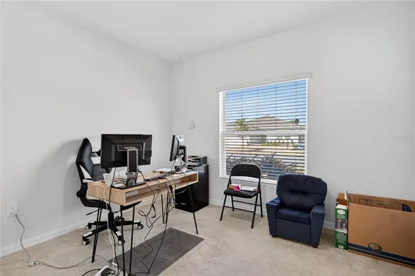 a view of a workspace with furniture and a window