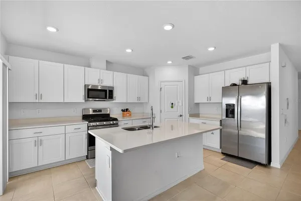 a kitchen with stainless steel appliances a refrigerator sink and stove
