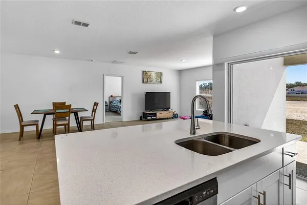 a kitchen with a sink a counter and chairs