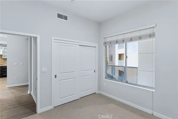 a view of empty room with wooden floor and cabinet