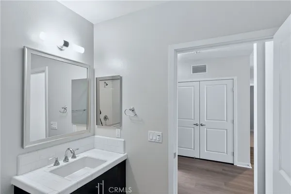a bathroom with a sink vanity granite tub and shower