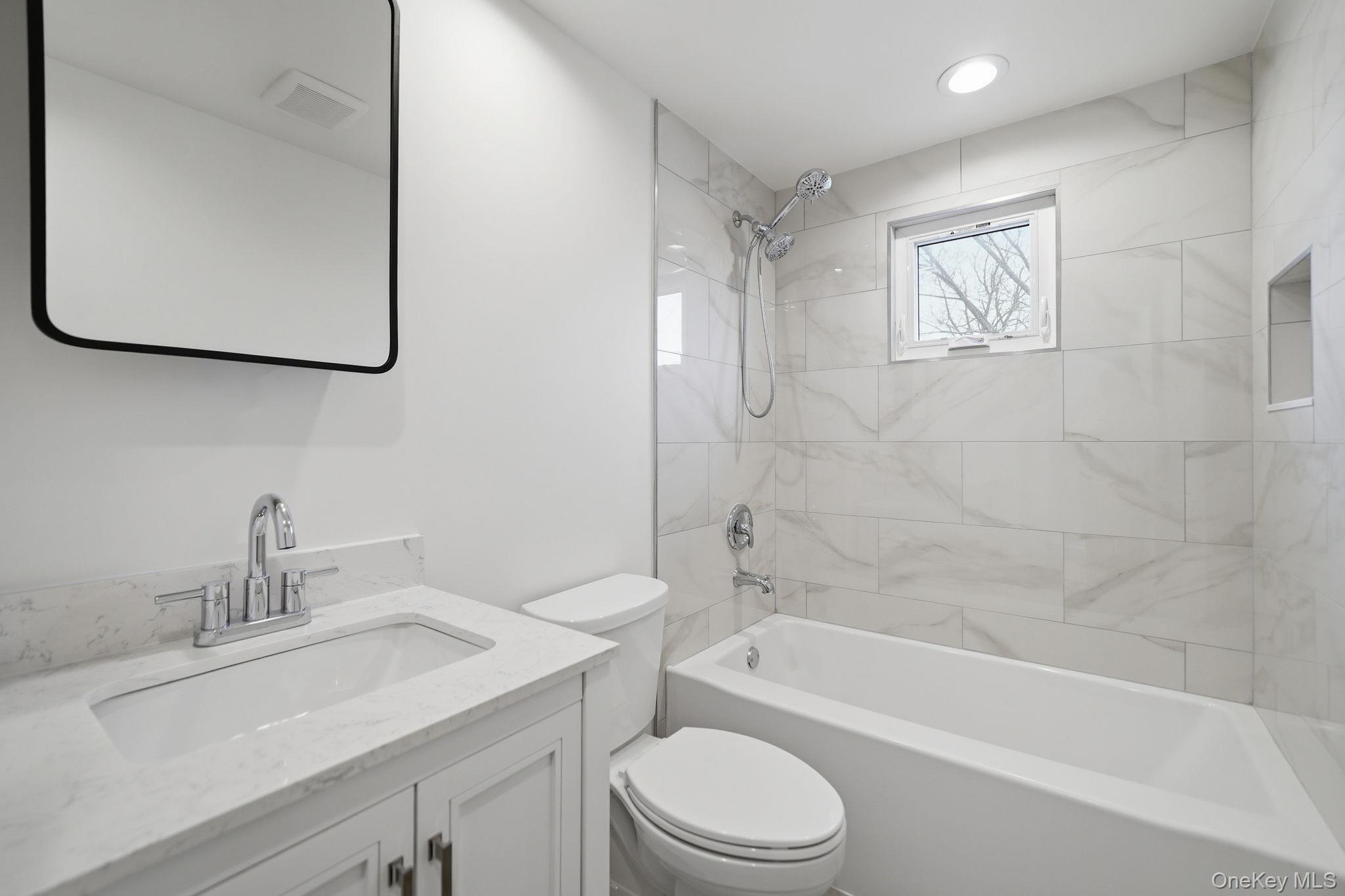 92 Hawthorne Road Kings Park, NY 11754 - Photo 15 of 33 a bathroom with a granite countertop sink a toilet and a bathtub