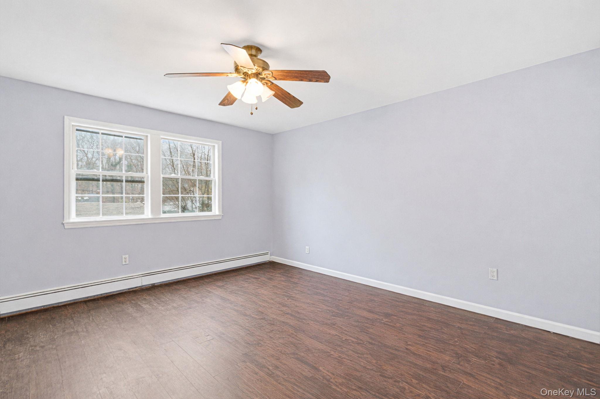 92 Hawthorne Road Kings Park, NY 11754 - Photo 27 of 33 an empty room with wooden floor fan and windows