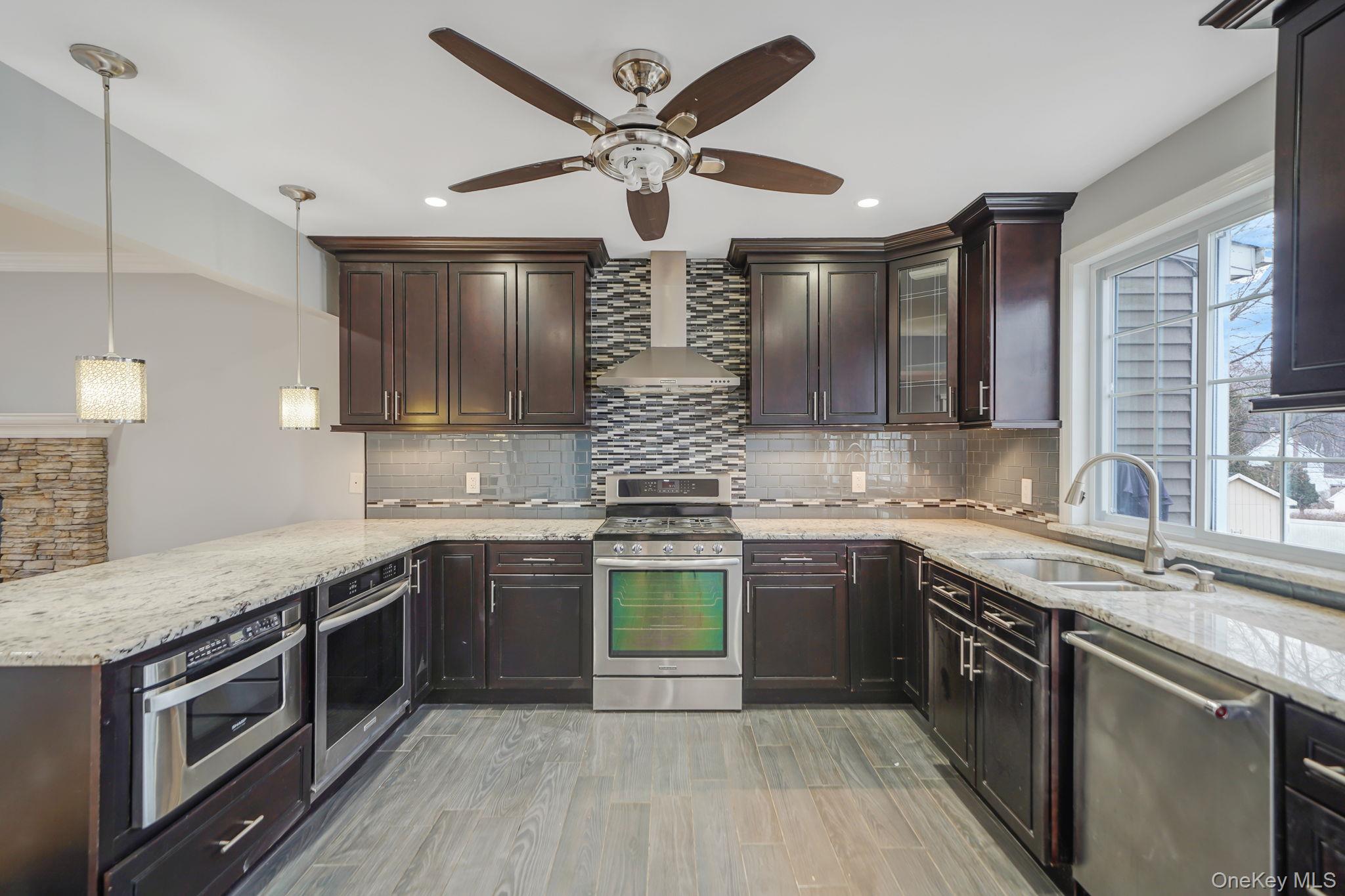 92 Hawthorne Road Kings Park, NY 11754 - Photo 3 of 33 a kitchen with stainless steel appliances granite countertop stove a sink and a refrigerator