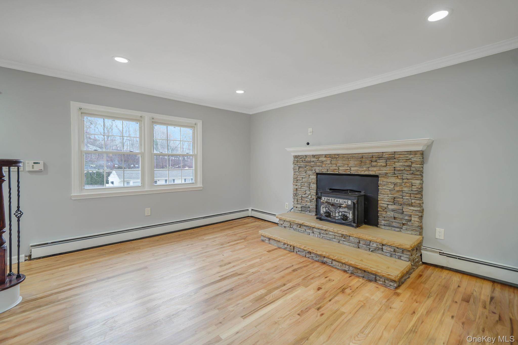 92 Hawthorne Road Kings Park, NY 11754 - Photo 7 of 33 an empty room with windows and fireplace