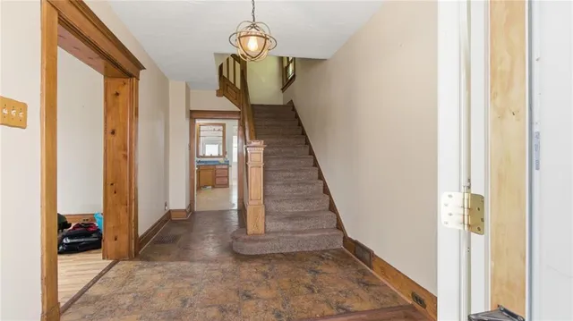 a view of a hallway with wooden floor and staircase