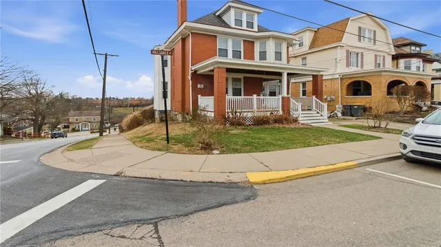 a view of a white house with a yard and plants