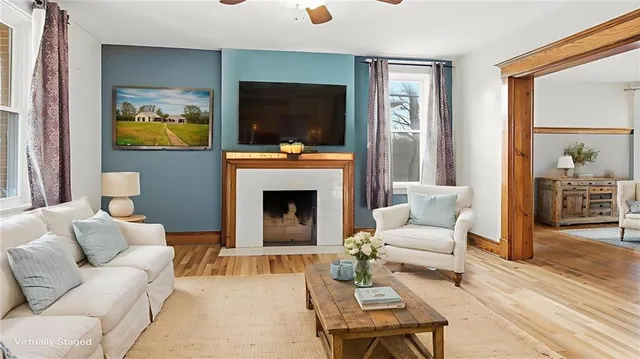 a living room with furniture a flat screen tv and a fireplace