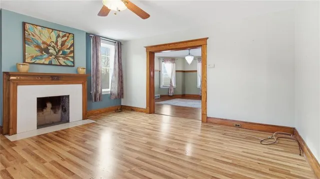 a view of empty room with wooden floor and fireplace