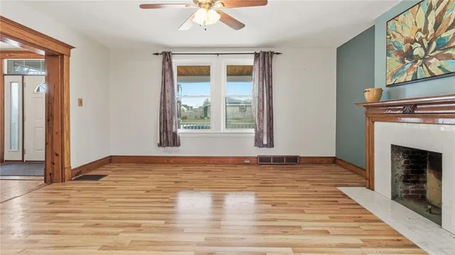 a view of an empty room with window and fireplace