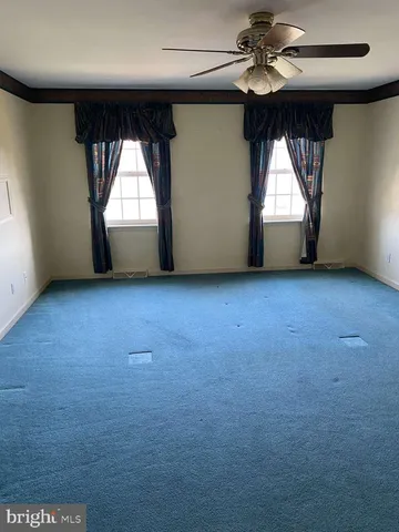 an empty room with a window and a ceiling fan