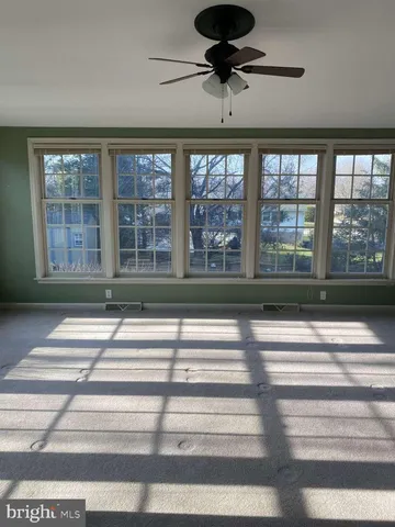 a view of a livingroom with a ceiling fan and window