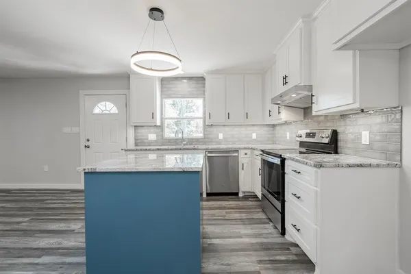 a kitchen with granite countertop a sink cabinets a window and stainless steel appliances