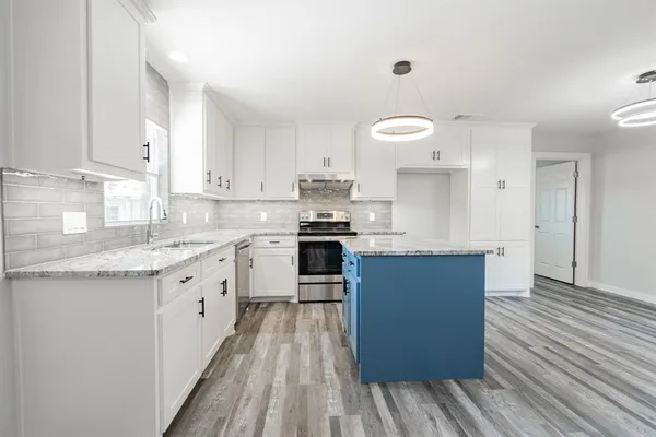 a kitchen with granite countertop stainless steel appliances and wooden cabinets