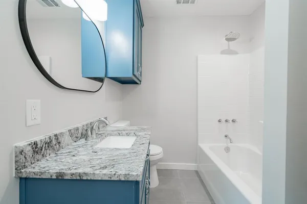 a bathroom with a granite countertop sink and a mirror