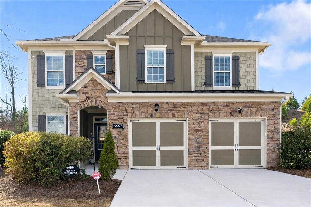 6667 Rivergreen Road Flowery Branch, GA 30542 - Photo 1 of 50 a front view of a house with a yard and garage