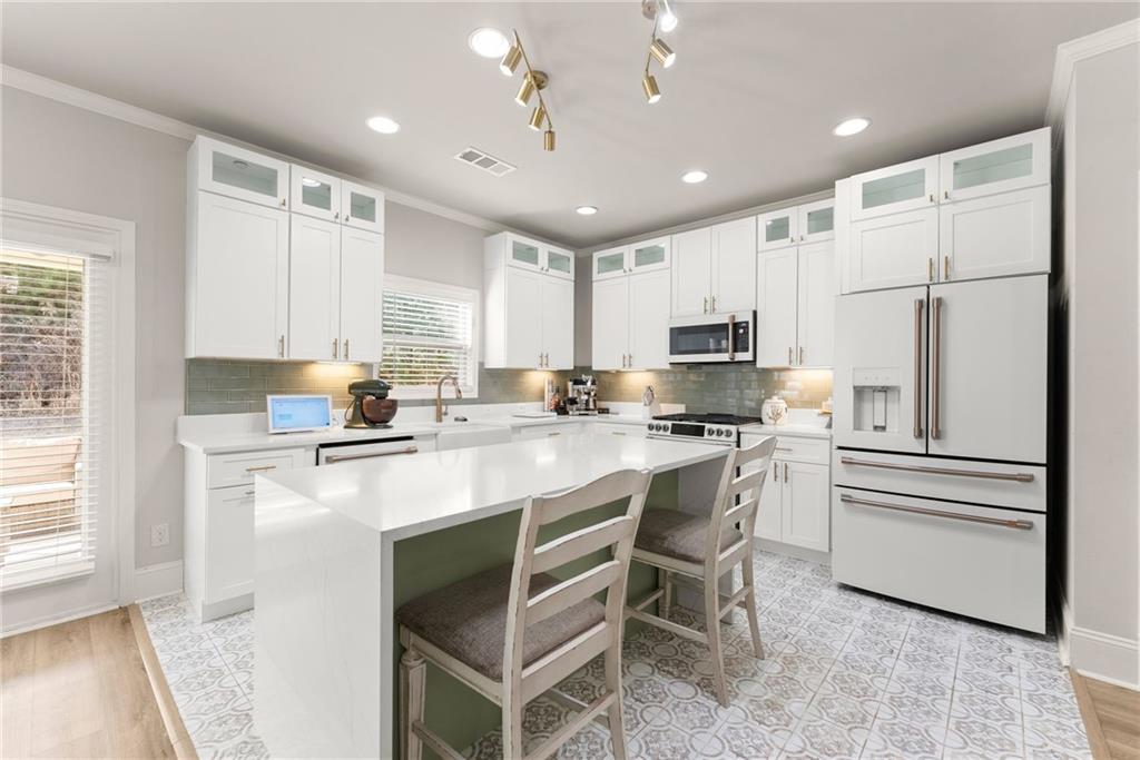 6667 Rivergreen Road Flowery Branch, GA 30542 - Photo 14 of 50 a kitchen with white cabinets and stainless steel appliances