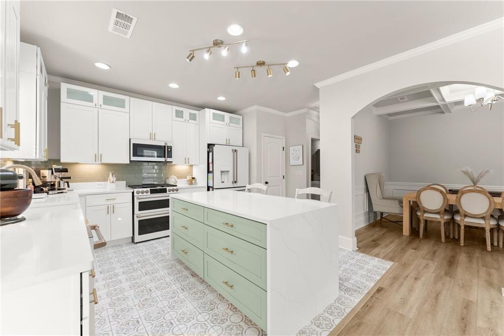 6667 Rivergreen Road Flowery Branch, GA 30542 - Photo 15 of 50 a kitchen with stainless steel appliances kitchen island granite countertop a stove top oven a sink dishwasher and a refrigerator with wooden floor