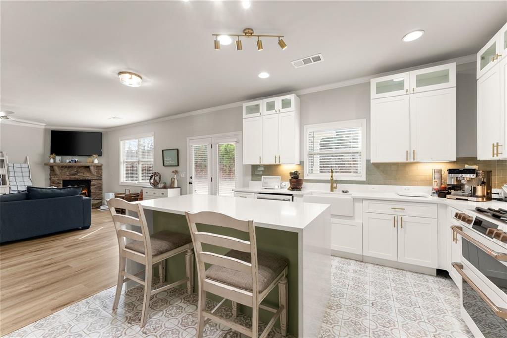 6667 Rivergreen Road Flowery Branch, GA 30542 - Photo 18 of 50 a kitchen with a sink chairs and counter space