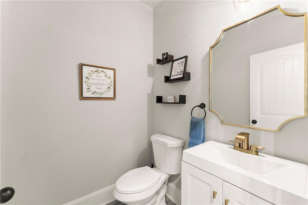 6667 Rivergreen Road Flowery Branch, GA 30542 - Photo 19 of 50 a white toilet sitting next to a bathroom sink