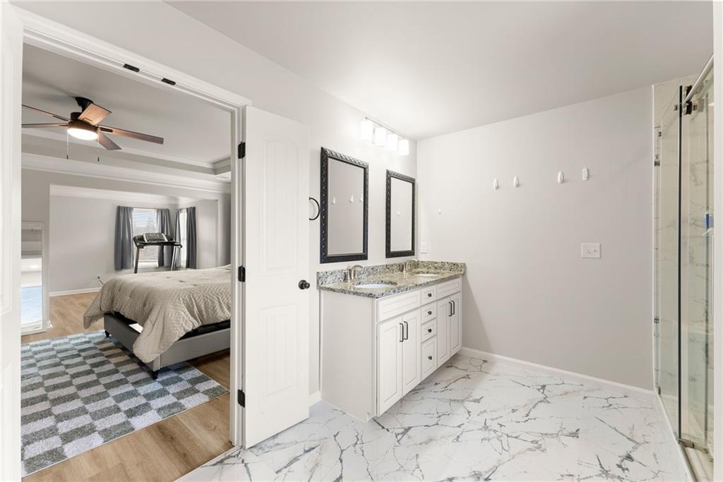 6667 Rivergreen Road Flowery Branch, GA 30542 - Photo 25 of 50 a spacious bathroom with a granite countertop sink and a mirror
